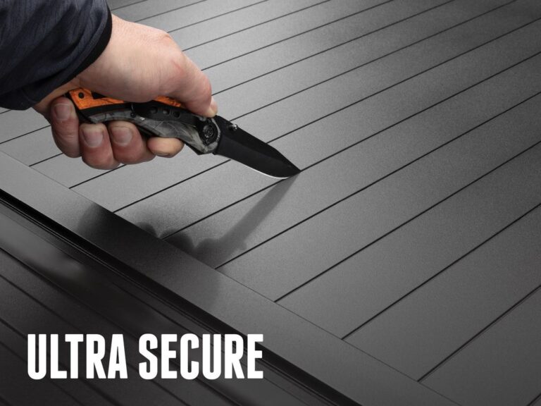 Hand pressing a knife against the closed FlushFit TS aluminum slats to demonstrate knife-proof security, ULTRA SECURE text overlay