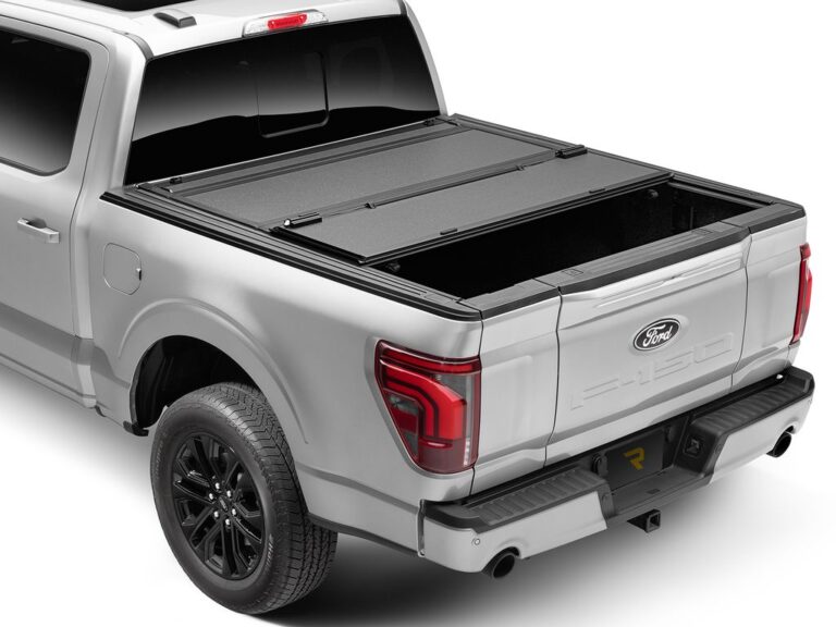 BAKFlip MX4 hard folding tonneau cover with rear panels flipped open and tailgate down on a silver Ford F-150, rear three-quarter angle on white background