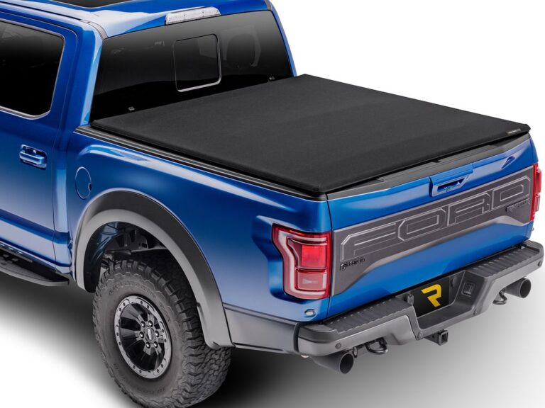Extang Trifecta Signature 2.0 soft folding tonneau cover fully closed on a blue Ford F-150 Raptor, rear three-quarter angle on white background