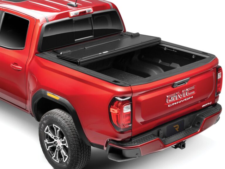 BAKFlip G2 hard folding tonneau cover partially folded open on a red GMC Canyon AT4, angled product shot on white background
