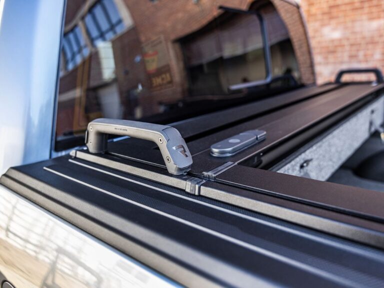 RetraxPRO EZ-OFF FRC-4000 cover installed on a silver Ford F-150, rear three-quarter view showing the low-profile matte black finish in a residential setting