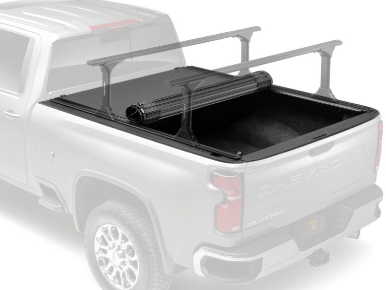 BAK Revolver X4TS hero marketing image with the cover rolled forward against the cab over a ghosted silver truck silhouette and crossbars on T-slot rails