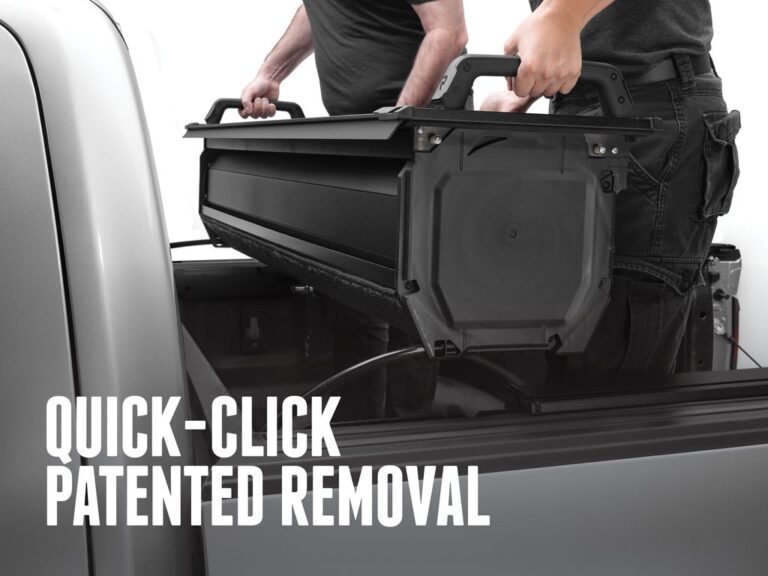 Two hands lifting the RetraxPRO EZ-OFF cover out of a truck bed using the integrated lift handles, demonstrating the QUICK-CLICK PATENTED REMOVAL feature