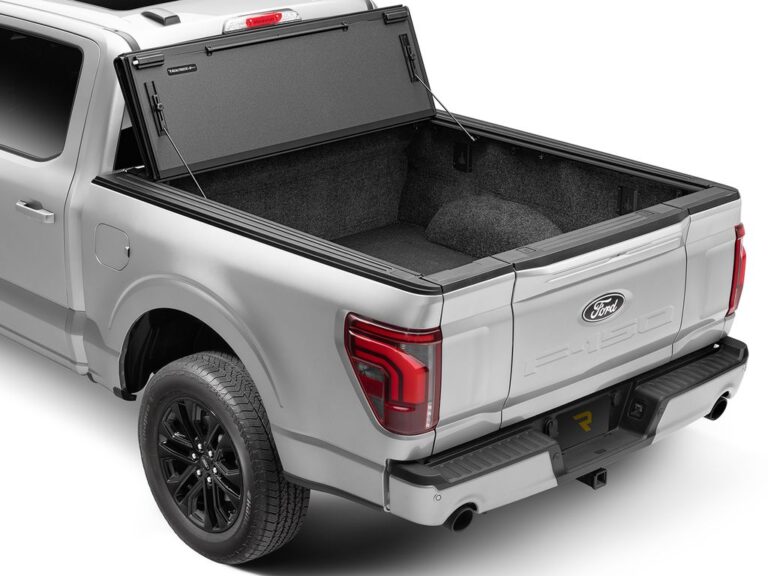 BAKFlip MX4 cover on a silver Ford F-150 with the rear panel flipped up and tailgate down, exposing the bed, rear three-quarter angle on white background