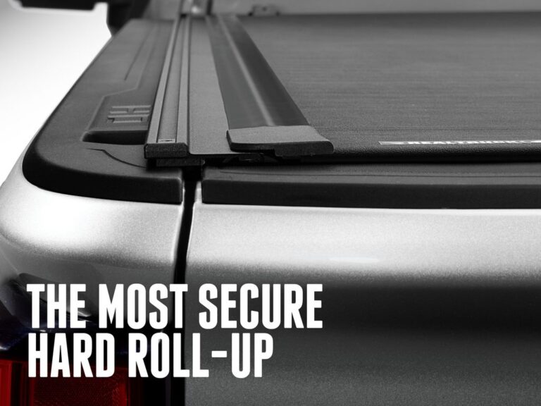 BAK Revolver X4TS marketing claim image reading THE MOST SECURE HARD ROLL-UP, close-up of the integrated T-slot rail and matte black cover surface on a silver truck