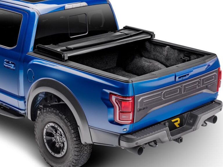 Extang Trifecta Signature 2.0 cover folded forward into the 2/3 bed access position on a blue Ford F-150 Raptor, rear three-quarter view
