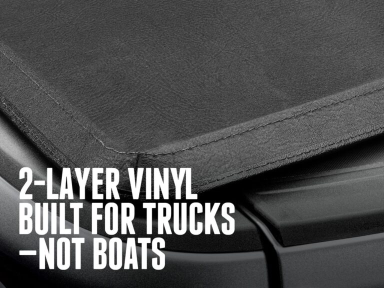 Close-up of the 2-layer, 40-grade RTxVinyl cover material stretched across the Trifecta E-Series bows, text overlay "2-LAYER VINYL BUILT FOR TRUCKS—NOT BOATS".