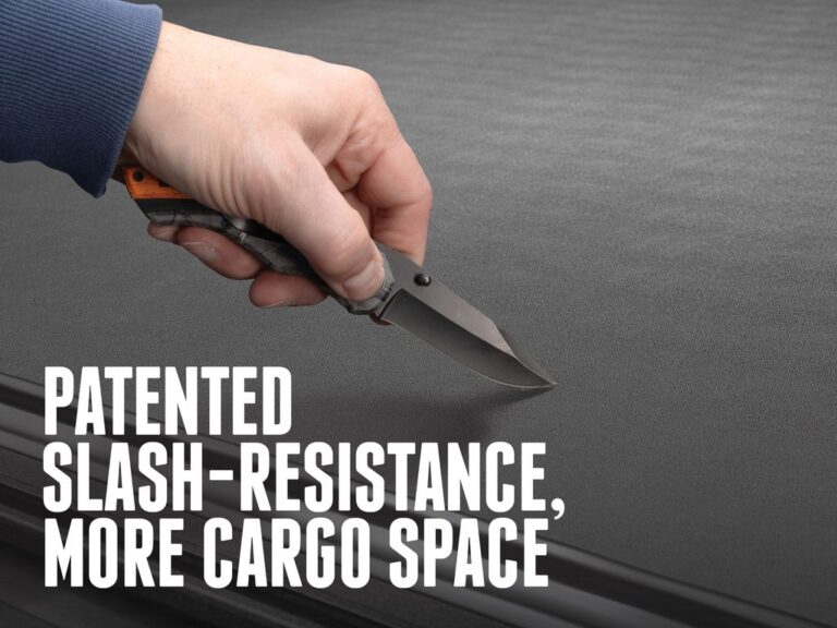 BAK Revolver X4TS marketing claim image reading PATENTED SLASH-RESISTANCE, MORE CARGO SPACE showing a hand with a utility knife attempting to slash the matte black cover surface