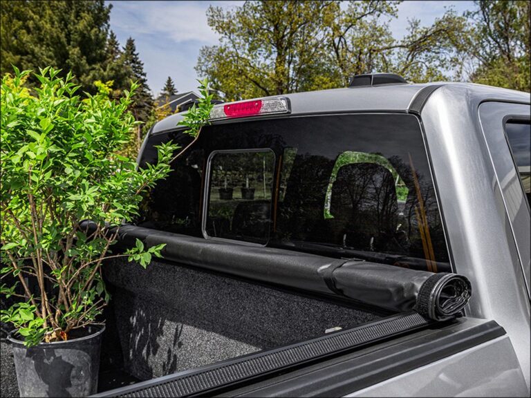 TruXedo TruXport GEN 2 lifestyle shot of a tan Toyota Tacoma 4x4 with the cover fully closed in a mountain meadow setting