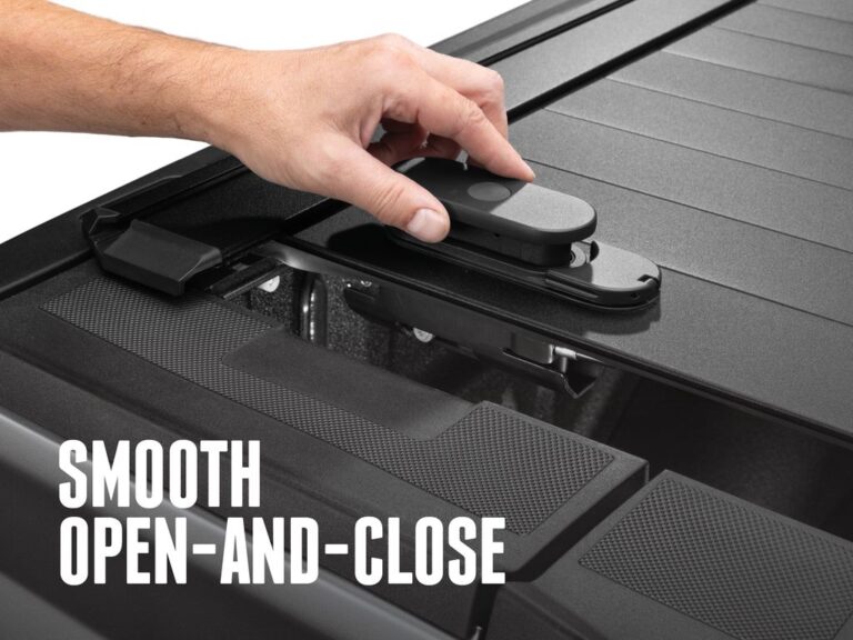 Hand operating the RetraxPRO EZ-OFF TraxLatch comfort handle on the closed cover, SMOOTH OPEN-AND-CLOSE text overlay, showing the premium-feel mechanism