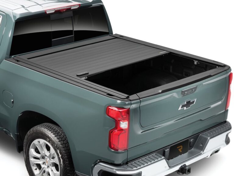 RetraxPRO MX retractable tonneau cover closed on a dark green heavy-duty truck, rear three-quarter angle on white background