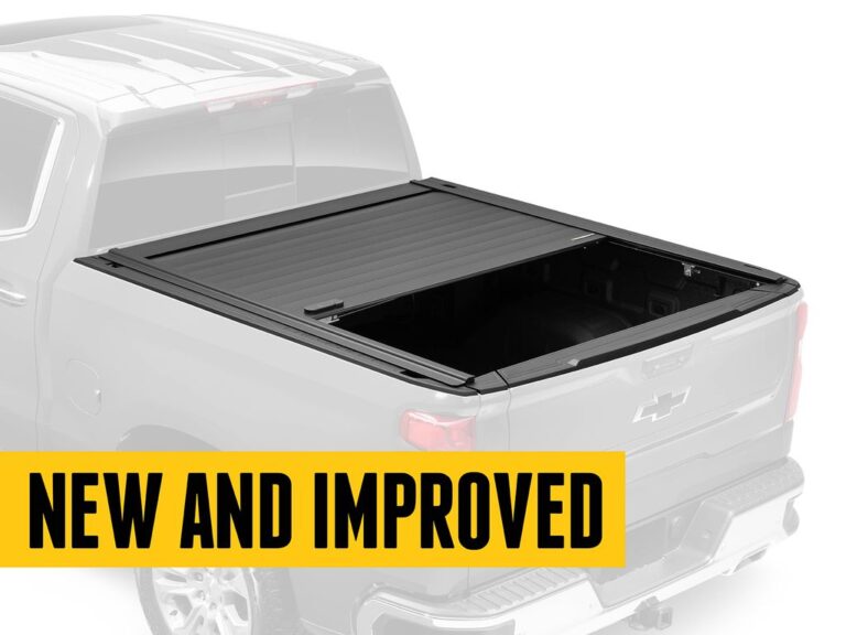 RetraxPRO MX retractable tonneau cover shown partially open with a hand gripping the TraxLatch handle, close-up action shot