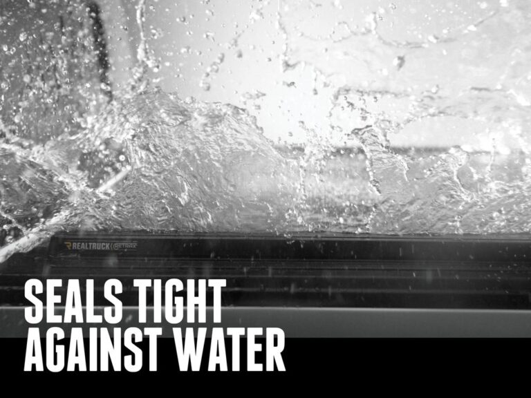 RetraxPRO MX cover edge with heavy water spray demonstrating weather sealing, SEALS TIGHT AGAINST WATER marketing overlay in black and white