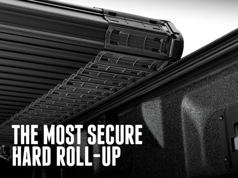Close-up of the BAK Revolver X4S slat and locking rail mechanism on a black truck showing the patented rotational locking rails, with text overlay reading the most secure hard roll-up