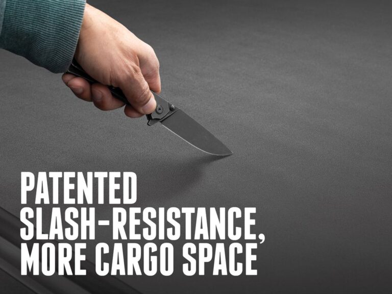 Marketing concept image of a hand holding a knife trying to slash the BAK Revolver X4S cover surface, demonstrating patented slash-resistance, with text overlay reading patented slash-resistance more cargo space