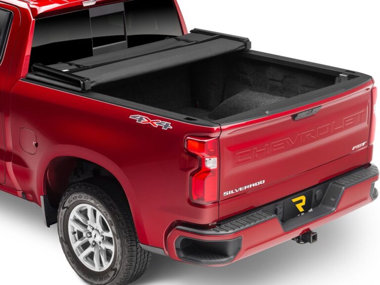 Red Chevy Silverado 4x4 with Trifecta 2.0 cover folded up forward against the cab, exposing the empty bed and tailgate down
